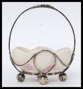 A Belleek ceramic dish, held within a white metal basket surround, makers marks to base.