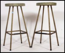 A pair of 1950's atomic style bar stools of tubular metal construction with the original vinyl