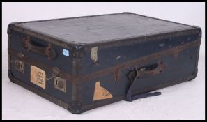 A vintage early 20th century travel trunk, having a hinged lid, travel labels, lined interior,