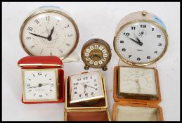 A collection of vintage alarm clocks and travel clocks.