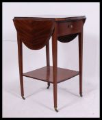 An early 20th century Edwardian mahogany drop leaf inlaid lamp table raised on tapering supports