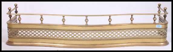 A large mid 19th century pierced brass fire fender kerb having spindle gallery top rail with