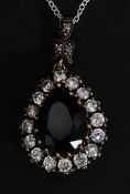 A contemporary silver pear shaped pendant and necklace set with CZ's and faux emerald stone.