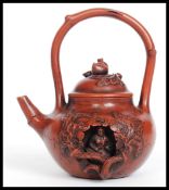 A 20th century terracotta Contemplation Yixing Teapot having a recess containing a Buddha inside,