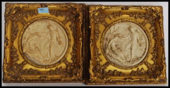 A pair of Parian ware style plaques being mounted in a gilt frame of rococo form.
