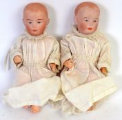 DOLLS: A pair of antique bisque headed composition bodied miniature childrens dolls.