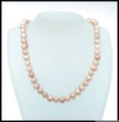 A Japanese chunky cultured and agitated pearl necklace of pinkish hue colouration