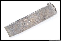 A silver 925 collar bangle being chased with foliate design being hallmarked for NW 925,