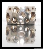 A silver modernist ladies dress ring of pierced band form with graduating circle style. Size L.
