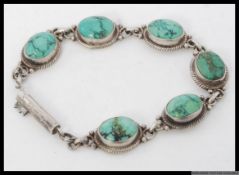 A silver and turquoise cabachon link bracelet stamped 925. Weight 20.6g.