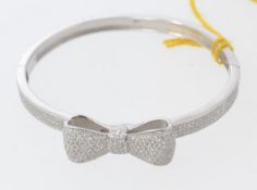 A ladies decorative silver and cz stone inset bangle with bow decoration to centre. Total weight 17.