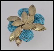 A large costume jewellery turquoise setbrooch in the form of a flower head.