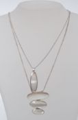 Two contemporary mother of pearl pendant necklaces on chains stamped 925. Weight 20g.