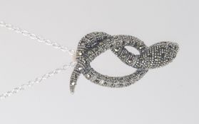 A silver and marcasite snake pendant set on a silver chain. Total weight 7.2g.