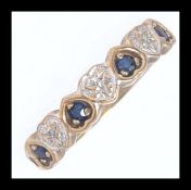 A 9ct gold, sapphire and diamond half eternity ring. The stone set in hearts.