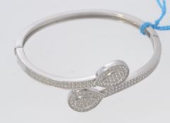 A ladies 925 silver and cz stone inset crossover bangle with teardrop shaped heads. Total weight 16.