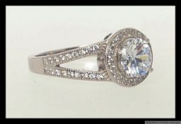 A 925 silver halo ring set with a large central brilliant cut CZ gem surrounded by a halo of CZ