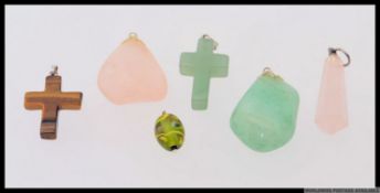 A collection of necklace pendants to include tigers eye agate cross, jade style glass cross,
