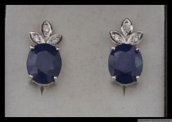 A pair of good quality designer  925 silver earrings with central oval cut blue gem stone