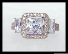 A 925 silver dress ring set with a large central princess cut CZ gem with pave set and baguette CZ