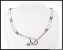 A 1950s white metal stylized snake choker necklace with clip clasped and oxidised and planished