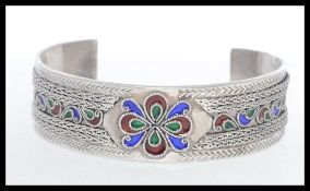 A heavey cloisonne and filigree deorated silver bangle. Stamped 925.