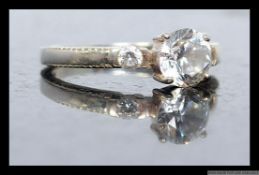 A ladies silver 925 dress ring with round cut CZ stone being claw mounted having round cut shoulder