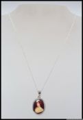 A 925 silver pendant necklace with inset enamel miniature of a 19th century Italian maiden in a red