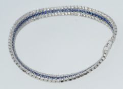 A contemporary  silver cz stone and sapphire set tennis bracelet, each stone being claw mounted.
