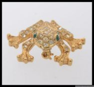 A vintage stylised frog brooch with pave set rhinestones complete with green rhinestone eyes with