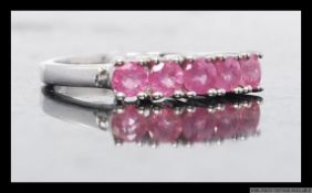 A silver 925 ladies dress ring having 5 channel set pink sapphire style gemstones. Size N.5.
2.