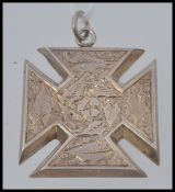 A sterling silver large necklace pendant in the form of a Maltese cross being chase decorated with