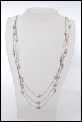 A vintage designer silver graduated triple string silver bead necklace. 925 sunrise mark to clasps.