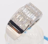 A contemporary  silver cz dress ring, the stones being baguette cut and inset to centre.