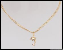 A 9ct gold chain and pendant. The pendant in the form of a dolphin.