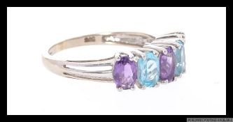 A 9ct white gold ring set with 5 alternating marquise cut blue and purple gemstones. Marked 375 GS.