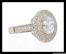 A 925 silver twin halo ring set with central oval cut CZ surrounded by twin encrusted CZ halos with