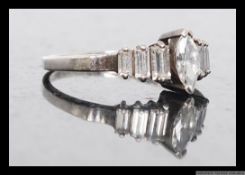 A silver ladies dress ring with central marquise cut CZ stone flanked by graduated baguette cut CZ