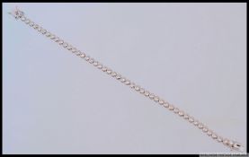 A 925 silver deigner CZ set tennis bracelet. Length 17cms. Weight 8g.