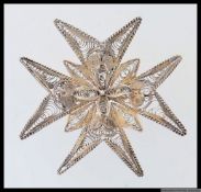 A large vintage white metal filigree Maltese Cross can be worn as a pendant or a brooch. Measures 5.