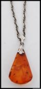 A silver and amber pendant and necklace chain. The amber pendant of drop form with rope style chain.