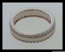 A 925 silver eternity ring with twin bands of channel set CZ within a red velvet presentation box.