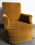 An early 20th century armchair having yellow velour upholstered overstuffed and sprung frame