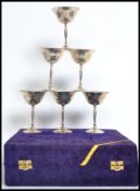 A case of six silver metal wine goblets having a  hand beaten effect presented in a blue velvet
