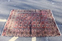 An early 20th century Indian style red ground floor rug, with geometric pattern design.