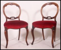 A pair of late 19th early 20th century red velvet upholstered mahogany balloon back bedroom chairs