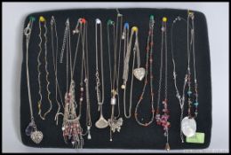 A collection of silver and white metal ladies necklaces with pendants.