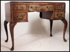An early 20th century walnut writing desk, in George II style, shaped top, leather writing surface,