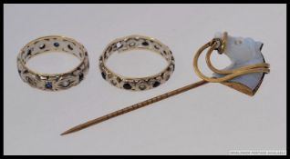 A 9ct gold and silver eternity ring together with a silver eternity ring and a yellow metal stick