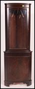 A Regency style mahogany corner cabinet having cupboard to the base with astragal glazed display